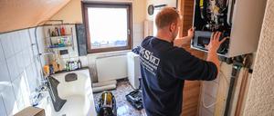 ARCHIV - 01.03.2023, Sachsen, Markranstädt: Ein Mitarbeiter einer Sanitär- und Heizungsbaufirma installiert eine moderne Gasbrennwerttherme in einem Einfamilienhaus. (zu dpa «Söder: Pläne für Heizungstausch sind gegen Eigentümer gerichtet») Foto: Jan Woitas/dpa +++ dpa-Bildfunk +++