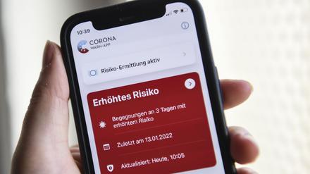 Auf einem Smartphone zeigt die geöffnete Corona-Warn-App ein erhöhtes Risiko an.