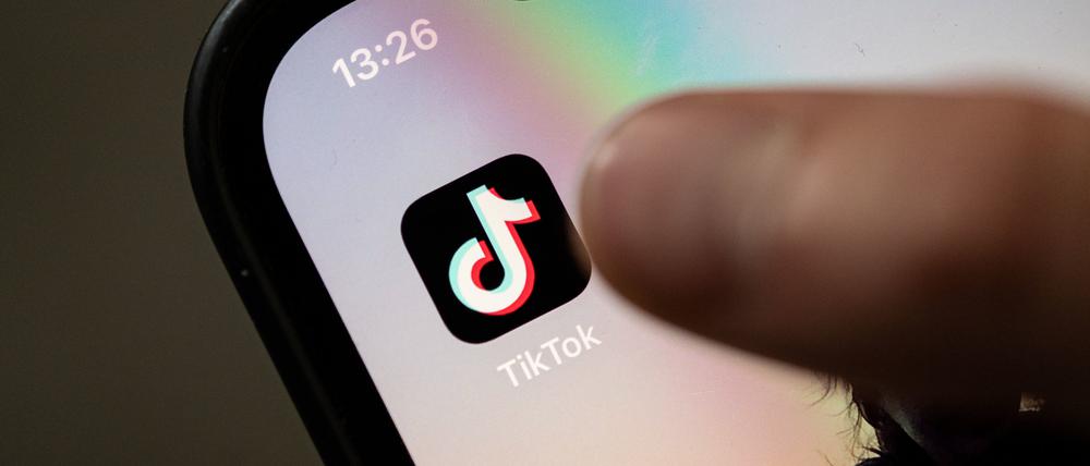 Ein Teenager tippt auf das Icon der Tiktok-App auf einem Smartphone.