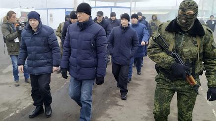 Ein von Russland unterstützter Separatistensoldat (r) begleitet eine Gruppe von ukrainische Kriegsgefangene in der Nähe des Kontrollpunktes Horliwka, Ostukraine, bei einem Gefangenenaustausch (Archivbild).