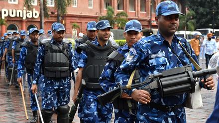 India's Rapid Action Force (RAF) personnel patrol along a street during a hunt for Sikh separatist, in Amritsar on March 20, 2023. - Mobile internet in India's Punjab state remained suspended for a third day on March 20 as police hunted a radical Sikh preacher and protestors vandalised consulates abroad. (Photo by Narinder NANU / AFP)