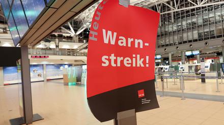 Ein Plakat mit dem Text ·Warnstreik· hängt im menschenleeren Terminal 2 im Flughafen Hamburg. 