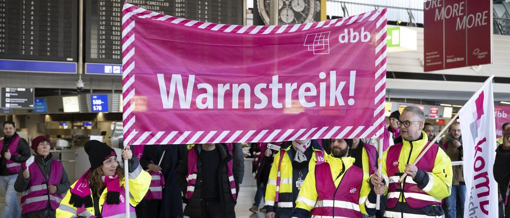 Streikende laufen mit Bannern durch das Terminal des Flughafens Frankfurt.