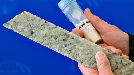 Brandenburg, Guben, 2023: Ein Mitarbeiter von Rock Tech zeigt einen kleinen Behälter mit Lithiumhydroxid und das Lithiummineral Spodumen auf dem Baugelände für eine Lithiumfabrik des kanadischen Unternehmens Rock Tech.
