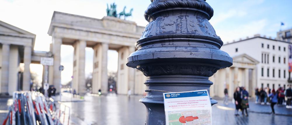 Ein Schild der Polizei mit dem rot markierten Sicherheitsbereich rund um den Pariser Platz und dem Brandenburger Tor hängt an einem Laternenpfahl. 