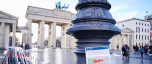 Ein Schild der Polizei mit dem rot markierten Sicherheitsbereich rund um den Pariser Platz und dem Brandenburger Tor hängt an einem Laternenpfahl. 