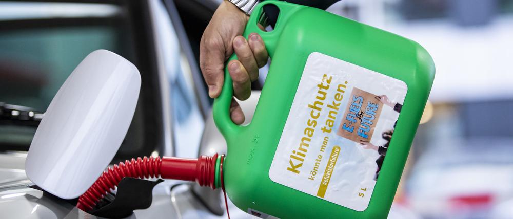 Ein Auto wird mit einem Kanister mit der Aufschrift «Klimaschutz könnte man Tanken - E-Fules for Future» an einer Tankstelle mit E-Fuel betankt.