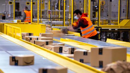 Mitarbeiter sortieren Paketsendungen des Online-Händlers Amazon in einem Verteilzentrum.
