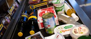 Lebensmittel liegen in einem Supermarkt an der Kasse auf dem Band.