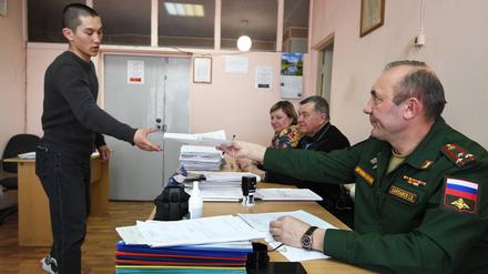 Ein Wehrpflichtiger erhält am Sammelpunkt eines Rekrutierungsbüros in Nowosibirsk seine Dokumente.