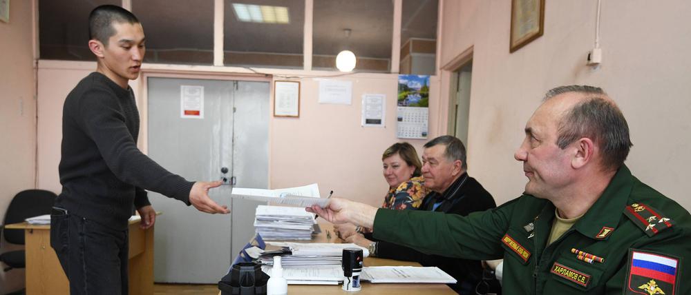 Ein Wehrpflichtiger erhält am Sammelpunkt eines Rekrutierungsbüros in Nowosibirsk seine Dokumente.