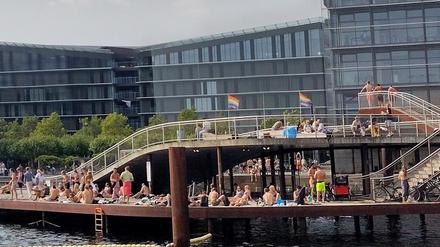 Menschen freuen sich im Zentrum Kopenhagens über das sonnige Wetter. Leitern ermöglichen ihnen einen komfortablen Zugang zum Wasser. 