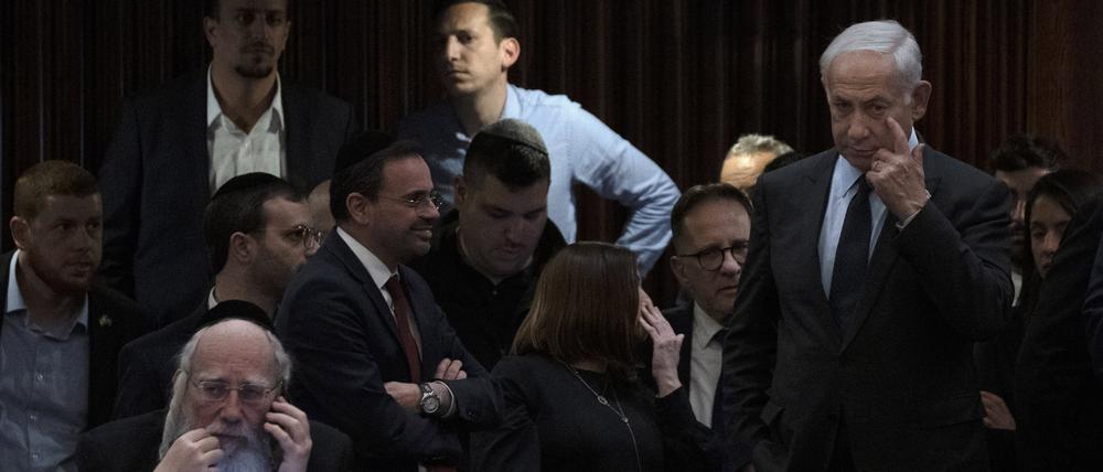 Benjamin Netanjahu (r), Ministerpräsident von Israel, nimmt an einer Abstimmung in der Knesset, dem Parlament des Landes, teil während draußen Menschen gegen den Plan seiner Regierung protestieren.