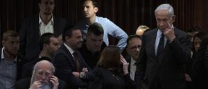 Benjamin Netanjahu (r), Ministerpräsident von Israel, nimmt an einer Abstimmung in der Knesset, dem Parlament des Landes, teil während draußen Menschen gegen den Plan seiner Regierung protestieren.