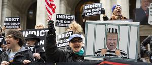 Demonstranten in New York halten Schilder mit einem Bild von Donald Trump im Gefängnis und Schildern mit der Aufschrift „Anklage der Putschisten“ hoch.