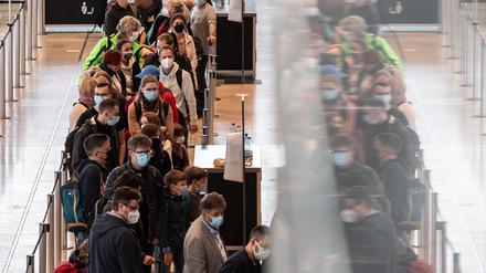Dicht an dicht stehen Reisende am Flughafen BER vor einem Check-in-Schalter.