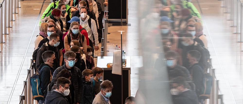 Dicht an dicht stehen Reisende am Flughafen BER vor einem Check-in-Schalter.