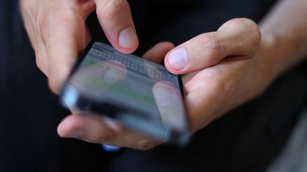 ARCHIV - 06.07.2022, Bayern, Augsburg: Ein junger Mann tippt auf einem Smartphone eine WhatsApp Nachricht. Etwa 680 000 Kinder und Jugendliche in Deutschland sind einer 2023 bekannt gegebenen Studie zufolge süchtig nach Computerspielen und sozialen Medien. (zu dpa «Studie: Sechs Prozent der Minderjährigen abhängig von sozialen Medien») Foto: Karl-Josef Hildenbrand/dpa +++ dpa-Bildfunk +++