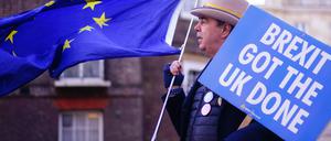 "Brexit git the UK done" steht auf einem Plakt, das ein Mann bei seinem Anti-Brexit-Protest zusammen mit einer Europa-Fahne vor dem Lancaster House in London zeigt. +++ dpa-Bildfunk +++