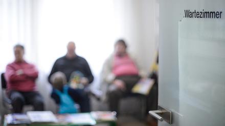 Patienten warten im Wartezimmer einer Arztpraxis. 