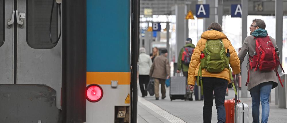 Fahrgaeste gehen mit ihrem Gepaeck auf einem Bahnsteig am Hauptbahnhof in Muenchen.
