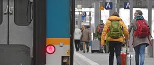Fahrgaeste gehen mit ihrem Gepaeck auf einem Bahnsteig am Hauptbahnhof in Muenchen.