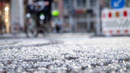 Berlin: Hagelkörner liegen nach einem Schauer auf einer Straße. 