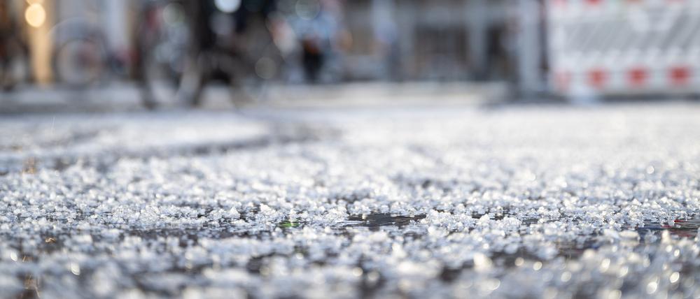 Berlin: Hagelkörner liegen nach einem Schauer auf einer Straße. 