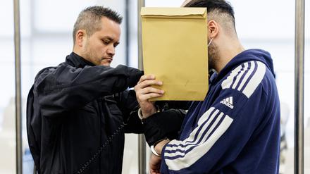 Der Angeklagte Abdul Majed R.  (r) wird von Justizbeamten in Handschellen in den Gerichtssaal des Oberlandesgerichts Dresden geführt.