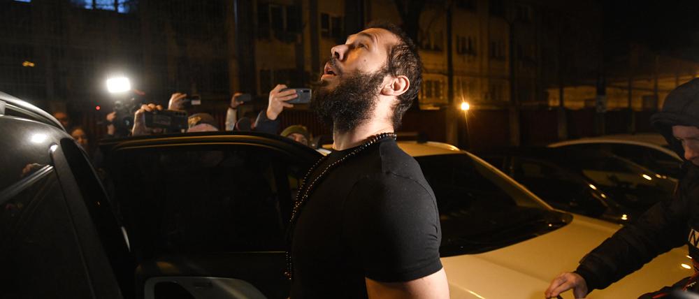 Andrew Tate blickt mit dem Koran in der Hand nach oben, nachdem er aus dem Gefängnis entlassen wurde.