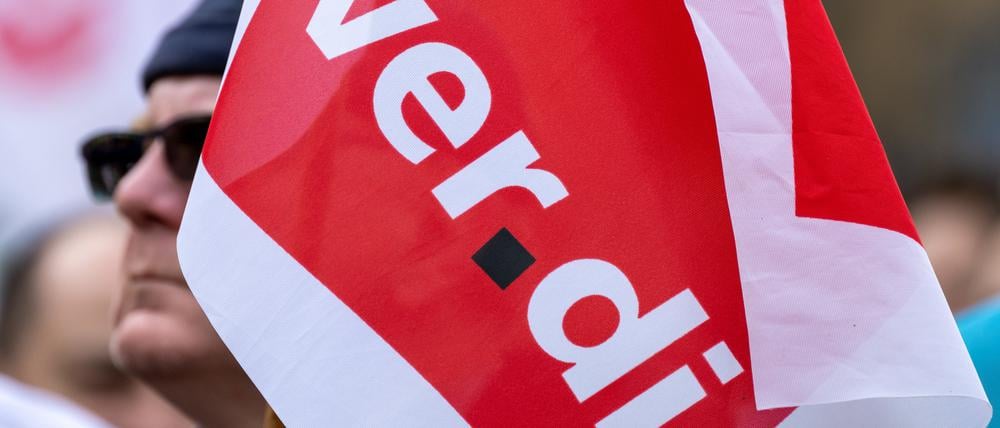 Fahnen der Dienstleistungsgewerkschaft Verdi schwenken Teilnehmer auf der Warnstreikkundgebung.