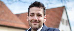 Ryyan Alshebl (Bündnis 90/Die Grünen) sitzt in Ostelsheim auf einer Bank.