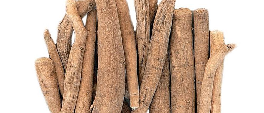 Ginseng ashwagandha herb root and korean powder over bamboo background.