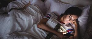 Woman using mobile phone while lying on bed at bedroom