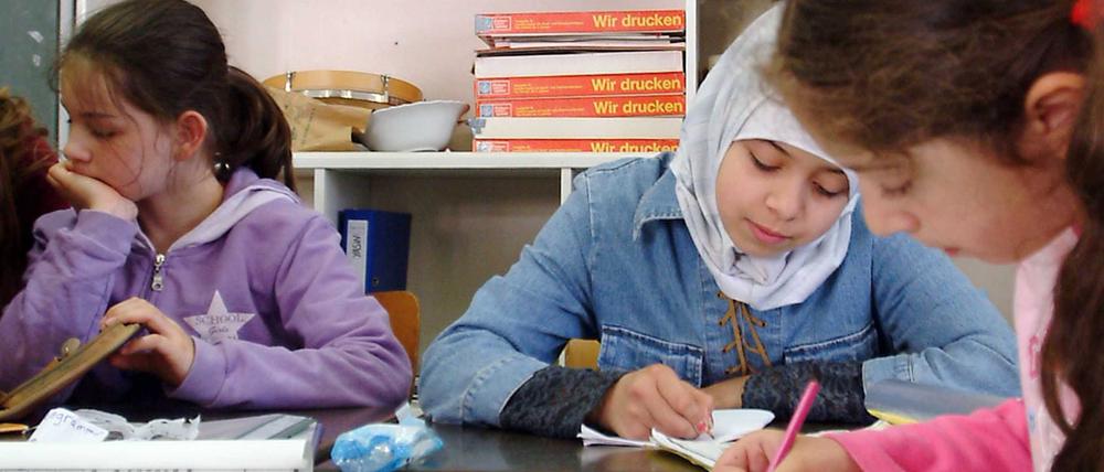 Schüler und Schülerinnen einer Grundschule in Berlin-Kreuzberg lernen mit ihrer Lehrerin im Unterricht.