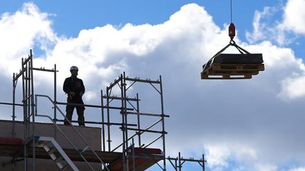 ARCHIV - 05.03.2021, Brandenburg, Potsdam: Ein Arbeiter dirigiert auf einer Baustelle einen Kran. Nach einem deutlichen Rückgang 2021 hat Brandenburg den Mietwohnungsneubau im vergangenen Jahr wieder stärker gefördert. (zu dpa: «Brandenburg fördert Bau von Mietwohnungen wieder stärker») Foto: Soeren Stache/dpa-Zentralbild/dpa +++ dpa-Bildfunk +++
