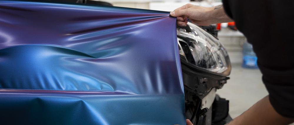 Beim Folieren werden alle lackierten Teile eines Autos beklebt. Die ursprüngliche Fahrzeugfarbe ist dann nur noch an Stellen wie den Türeinstiegen oder der Innenseite der Kofferraumklappe sichtbar.