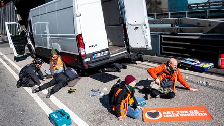 Klimaaktivisten haben sich auf der Fahrbahn der Autobahn 7 festgeklebt und blockieren so die Zufahrt des Elbtunnels in Richtung Norden.