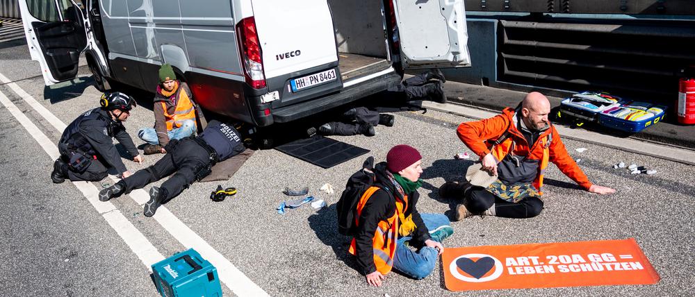 Klimaaktivisten haben sich auf der Fahrbahn der Autobahn 7 festgeklebt und blockieren so die Zufahrt des Elbtunnels in Richtung Norden.