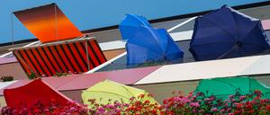 Bunte Sonnenschirme und Markisen auf Balkons einen Mehrfamilienhauses in Frankfurt (Oder). 