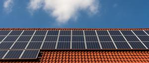 Solarzellen liegen auf einem Ziegeldach.