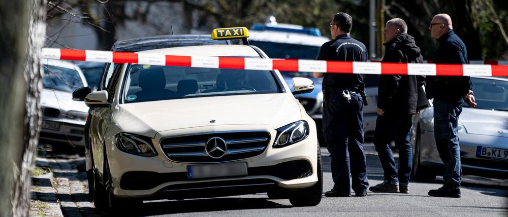 Mitarbeiter der Berliner Polizei steht vor dem Taxi in Berlin-Grunewald.