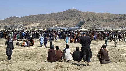 Menschen versammeln sich in der Nähe eines C-17-Transportflugzeugs der US-Luftwaffe auf dem Gelände des internationalen Flughafens in Kabul (Archivbild).