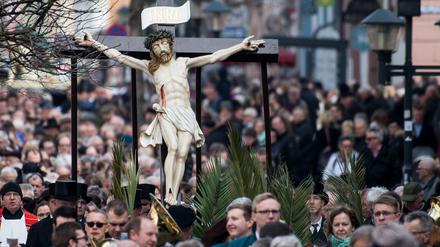 25.03.2018, Thüringen, Heilbad Heiligenstadt: Katholische Gläubige tragen bei der Palmsonntagsprozession überlebensgroßen Darstellungen, die das Leiden und Sterben Jesu Christi symbolisieren. Die Leidensprozession am Palmsonntag ist eine der größten dieser Art und wird immer am Sonntag vor Ostern begangen. Foto: Swen Pförtner/dpa-Zentralbild/dpa ++ +++ dpa-Bildfunk +++