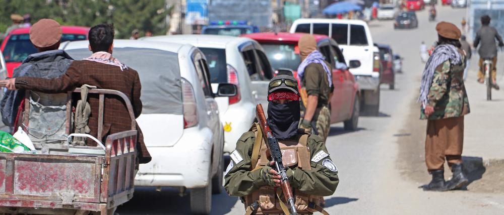 Taliban-Sicherheitskräfte sorgen dafür, dass an einem Kontrollpunkt im Bezirk Fayzabad die Tönungsfolien von den Autos der Pendler entfernt werden. 
