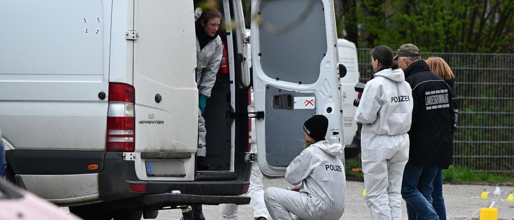   Mitarbeiter der Spurensicherung der Polizei untersuchen einen Tatort an dem mehrere Schüsse gefallen sind. 