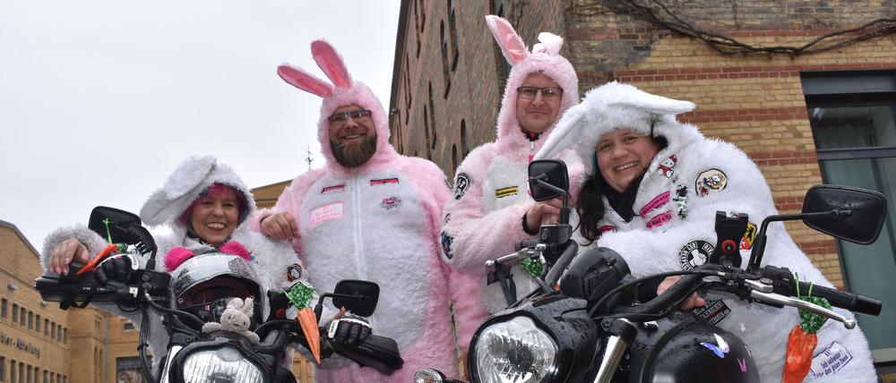 PRODUKTION - 09.04.2023, Berlin: Silvia Haas (l-r), John Wötzel, Marco Sternsdorf und Stefanie Gleditzsch, Mitglieder des Berliner Motorradvereins Streetbunnycrew, stehen mit ihren Motorrädern auf einem Parkplatz. Der Verein, dessen Mitglieder oft in einem Hasenoutfit unterwegs sind, sammelt Spenden. (zu dpa-Korr: «Donaldisten und Biker als Hasen - diese Vereine gibt es tatsächlich») Foto: Christian Thiele/dpa +++ dpa-Bildfunk +++