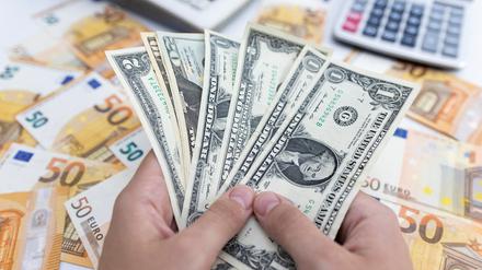 Ein Frau hält US-Dollar-Scheine.