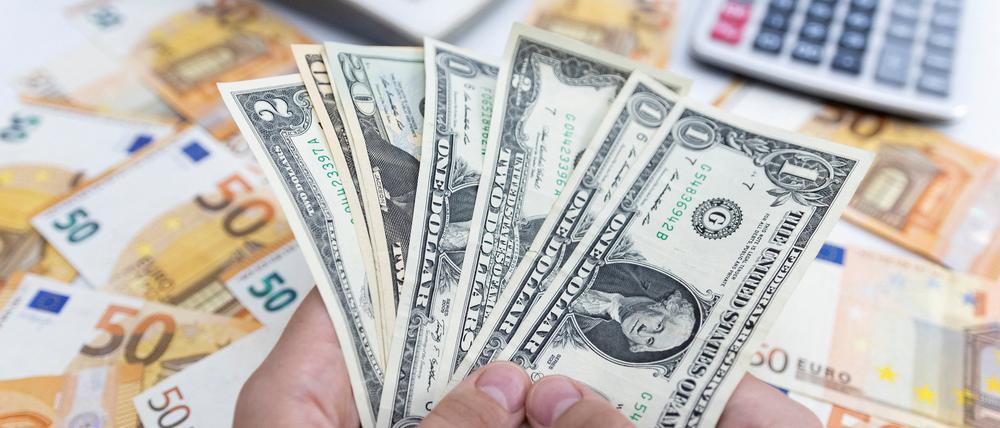 Ein Frau hält US-Dollar-Scheine.