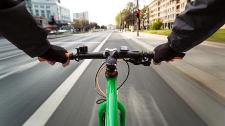 Cyclist drives on the bike path to a red traffic light - First-person view of cyclist/ motion blur